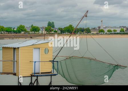 Capanne e reti da pesca lungo tutta la riva a St Nazaire, Francia Foto Stock