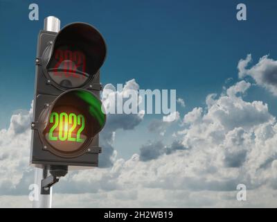 Semaforo con semaforo verde 2022 e rosso 2021 su sfondo cielo. Inizia il nuovo concetto di 2022 anni. illustrazione 3d Foto Stock