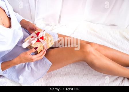 Ragazza sul letto contiene un regalo nelle sue mani spazio copia Foto Stock