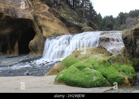 Una splendida cascata di schiuma nell'Hug Point state Recreation Site, un parco statale di Arch Cape, Oregon Foto Stock