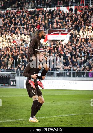 24 ottobre 2021, Amburgo: Calcio: 2° Bundesliga, Matchday 11, FC St. Pauli - Hansa Rostock al Millerntor Stadium. Simon Makienok di St. Pauli (sotto) e Daniel-Kofi Kyereh celebrano la loro vittoria dopo la partita. Foto: Christian Charisius/dpa - NOTA IMPORTANTE: In conformità con le norme della DFL Deutsche Fußball Liga e/o della DFB Deutscher Fußball-Bund, è vietato utilizzare o utilizzare fotografie scattate nello stadio e/o della partita sotto forma di immagini di sequenza e/o serie di foto di tipo video. Foto Stock