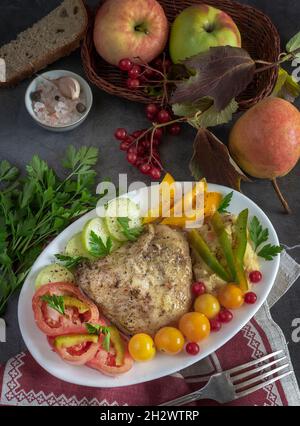 Coscia di pollo al forno su un piatto con verdure Foto Stock