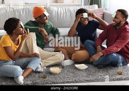 Divertenti amici neri che giocano a indovinare chi gioca a casa Foto Stock