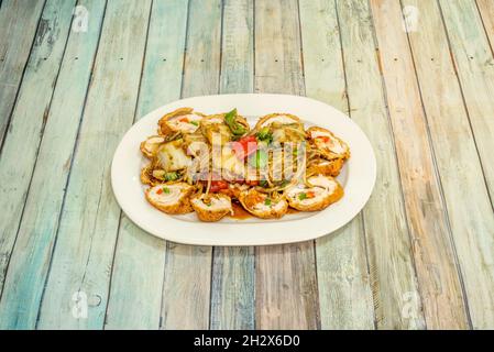 Ricetta peruviana di pollo arrotolato con tagliatelle e verdure saltate con salsa di soia su tavola di legno Foto Stock