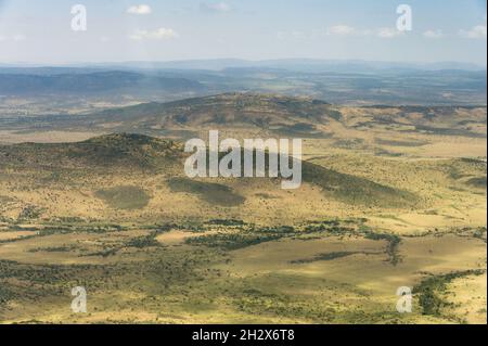 Vista aerea di ondulate colline semi aride punteggiate di alberi, Kenya Foto Stock