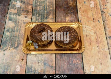 deliziose ciambelle al cioccolato con vassoio dorato Foto Stock