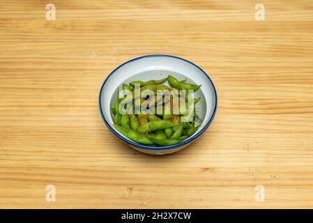 Ciotola di edamame in cialde cosparse di spezie calde Foto Stock