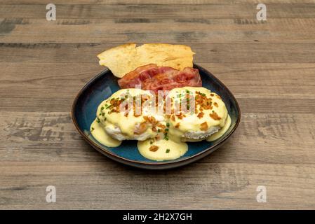 Uova Benedetto, piatto anglosassone con due metà di un muffin inglese, un pezzo di pane tostato o altri tipi di pane, di solito coperto con pancetta, broccia Foto Stock