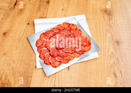 Porzione di lombo iberico tagliata a fette sottili su foglio di alluminio per il prelievo Foto Stock
