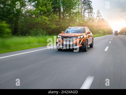 Kiev, Ucraina - 12 giugno 2021: Nuova Peugeot 2008 che guida in autostrada al tramonto Foto Stock