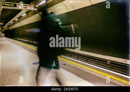 Immagine sfocata dei passeggeri che camminano su una piattaforma della stazione della metropolitana presso la stazione della metropolitana di London Bridge, scattata il 12th dicembre 2020 Foto Stock