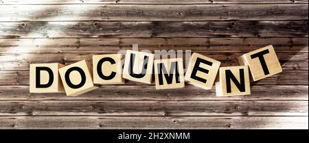 La parola documento scritto su un blocco di legno. I blocchi si trovano su un tavolo di legno per il vostro design, concetto. Foto Stock