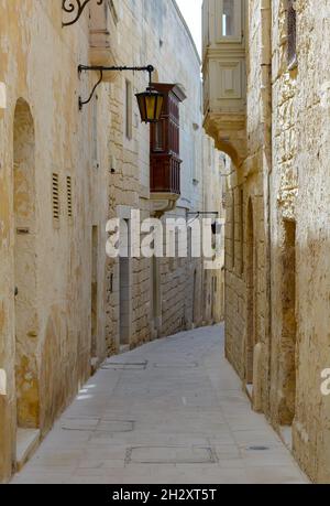 Tipica via Mdina. Stretta strada medievale di Mdina, conosciuta anche come "città silenziosa", pavimentata con lastre di pietra Foto Stock