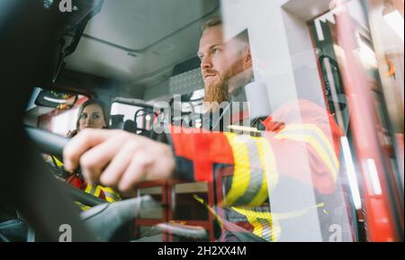 Conducente di un camion antincendio in azione Foto Stock