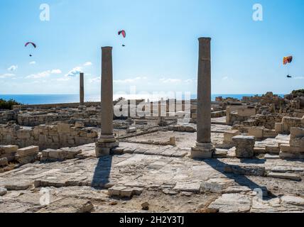 I parapendio scivolano sulle rovine della Basilica cristiana presso il sito archeologico di Kourion, Cipro. Foto Stock