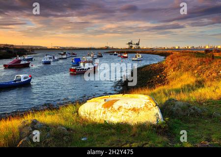 Imbarcazione in vetroresina capovolta in un piccolo molo di pesca a Redcar, vicino a Middlesbrough, North Yorkshire, Inghilterra, Regno Unito. Foto Stock