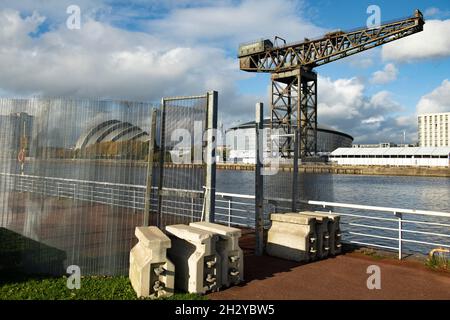 Glasgow, Scozia, Regno Unito. 24 ottobre 2021 NELLA FOTO: L'anello di recinzione di sicurezza in acciaio e le barriere anti-protestore si estendono intorno all'intero perimetro della zona COP26 con il Crown Plaza Hotel, l'edificio SEC Armadillo e la Finnieston Crane e L'OVO Arena sullo sfondo. Vista sul sito COP26 che mostra il fiume Clyde e il porto, con gli edifici del Campus Scottish Event (OVO Hydro Arena, SEC Armadillo e SECC), con il Crown Plaza Hotel e l'anello di sicurezza in acciaio che circonda l'area. Giorni fino ai Capi di Stato, insieme a migliaia di delegati, media e manifestanti Foto Stock