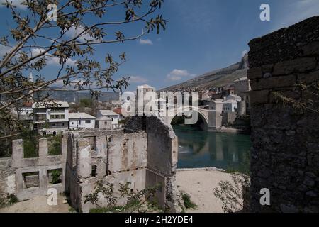Bosnien-Herzegowina, Mostar, Altstadt, Blick über zerstörte Hauser auf die Alte Brücke, Stari MOS, Neretva Fluss, città vecchia, vista sopra le case bombate a. Foto Stock
