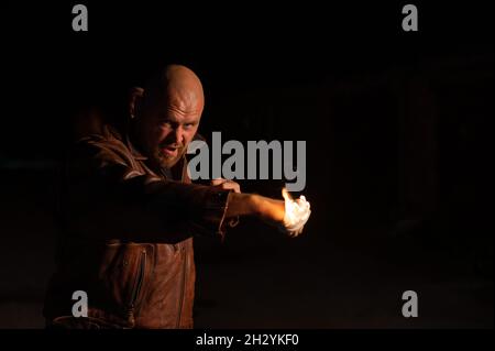 L'uomo caucasico calvo batte con un pugno ardente. Foto Stock