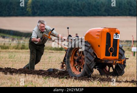 Uomo con aratro a mano solco per arare al 70° campionato britannico di aratura, Mindrum Mill, Northumberland, Inghilterra, Regno Unito Foto Stock