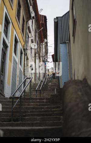 OPORTO, PORTOGALLO - 06 settembre 2021: Un colpo verticale di una strada stretta con scale a Oporto, Portogallo Foto Stock