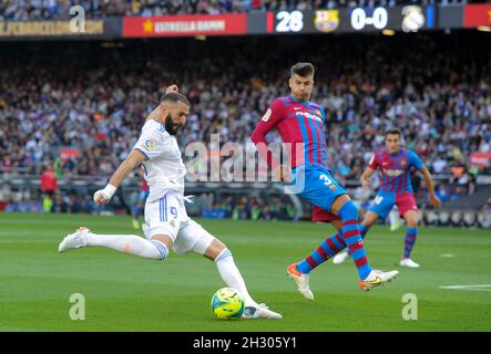 Barcellona, Spagna. 24 ottobre 2021. Gerard Pique (R) di Barcellona vibra con Karim Benzema del Real Madrid durante una partita di calcio del campionato spagnolo di prima divisione tra il FC Barcelona e il Real Madrid a Barcellona, in Spagna, il 24 ottobre 2021. Credit: Gustavo Valiente/Xinhua/Alamy Live News Foto Stock