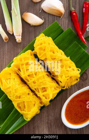 Il Roti Jala o la frittella di pizzo sono piatti tradizionali malesi, un popolare spuntino malese servito con piatti al curry Foto Stock