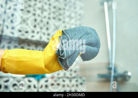 Una donna con guanti gialli pulisce l'ufficio Foto stock - Alamy