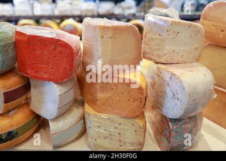 Diversi tipi di formaggi stagionati sono in vendita in un deli. Foto Stock