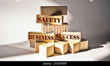 Testo di successo, affari, sicurezza scritto su blocchi di legno e sfondo bianco. Foto Stock