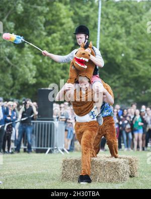 I frequentatori del Festival partecipano alla gara di cavalli pantomima il giorno 1 del Field Day, Victoria Park - Londra Foto Stock