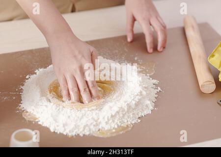 Mani di donna che fanno il movimento circolare per mescolare ingredienti liquidi e secchi per l'impasto della torta alla luna Foto Stock