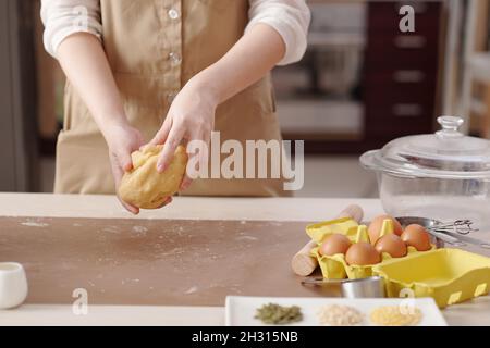 Immagine ritagliata della giovane donna impastando l'impasto per preparare le mooncake Foto Stock