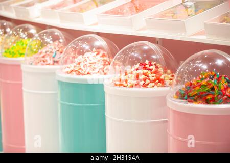 Caramelle di gelatina in contenitori in un deposito. Ampia selezione di dolci in diversi colori. Vendita di dolci. Foto Stock