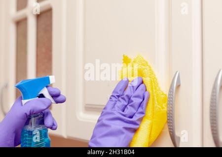 la mano della donna pulisce la porta della cucina da vicino Foto Stock