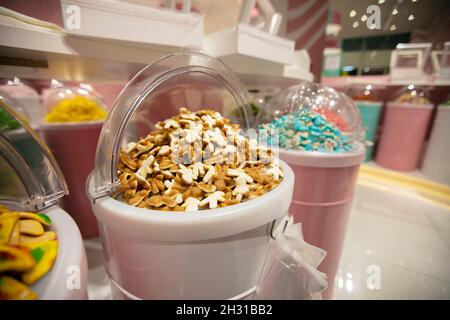 Caramelle di gelatina in contenitori in un deposito. Ampia selezione di dolci in diversi colori. Vendita di dolci. Foto Stock