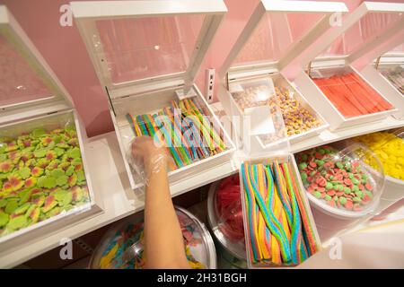 Caramelle di gelatina in contenitori in un deposito. Ampia selezione di dolci in diversi colori. Vendita di dolci. Foto Stock