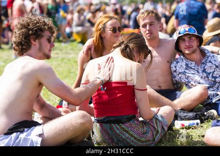 Il goer del festival ruba la protezione solare sulle sue amiche indietro il giorno 2 di Glastonbury 2019, Worthy Farm, Pilton, Somerset. Data immagine: Giovedì 27 giugno 2019. Il credito fotografico dovrebbe essere: David Jensen/EmpicsEntertainment Foto Stock