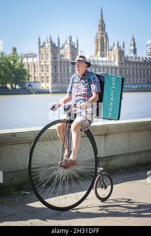 Un uomo consegna cibo per Deliveroo su una bicicletta Penny Farthing durante la pandemia del coronavirus, Westminster, Londra. Data foto: Lunedì 25 maggio 2020. Il credito fotografico deve essere: David Jensen/EMPICS Entertainment Foto Stock