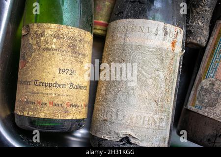 Neckargemuend, Germania - 11 settembre 2021: Bottiglie di vino molto vecchie con depositi da lunga cantina di stoccaggio come offerte in un mercato delle pulci Foto Stock