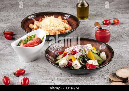 Varie insalate appetitose greche e caesar Foto Stock