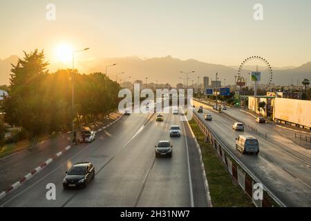 Strada trafficata nella città di Antalya al tramonto, Turchia Foto Stock