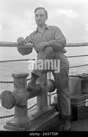 Ein Mann der Besatzung des Walfangfabrikschiffs 'Jan Wellem' bei einer pausa an der Reling, 1930er Jahre. Un membro dell'equipaggio della nave officina 'Jan Wellem' del tedesco flotta baleniera avente una pausa sulla ringhiera, 1930s. Foto Stock