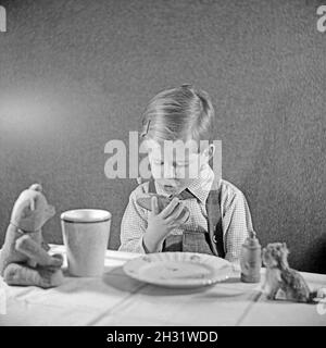 Ein kleiner Junge isst ein Butterbrot, Deutschland 1951. Un ragazzino che mangia il pane e il burro, Germania 1951. Foto Stock