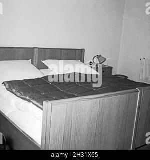 Inneneinrichtung im Schkafzimmer einer Pension, Deutschland 1958. Interno di una camera da letto in un ostello, Germania 1958. Foto Stock