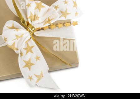 Scatola regalo dorata decorata con stelle a prua isolato su sfondo bianco. Foto Stock