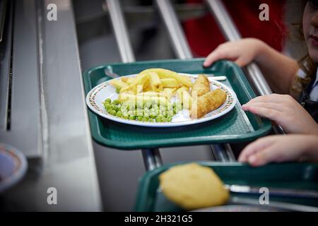 Cene scolastiche fish chips e piselli su un piatto Foto Stock