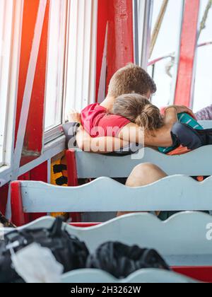 Vista posteriore dei passeggeri amanti della felicità che si abbraccia mentre si rilassano sul balcone godendo la vista dalla barca in mare. Felice coppia di turisti casual su t Foto Stock