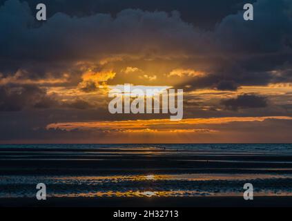 Una luce dorata e le nuvole drammatiche mentre il sole tramonta sul Mare di Nort sulla Costa Nord Norfolk. REGNO UNITO Foto Stock