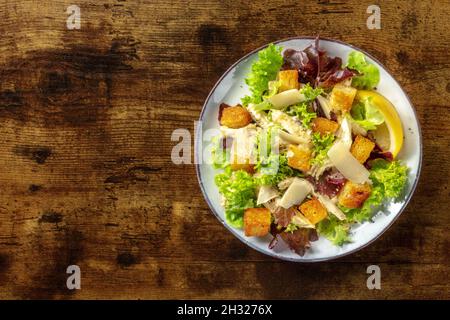 Insalata di Caesar di pollo, foto in testa su un sfondo rustico scuro in legno con spazio copia Foto Stock